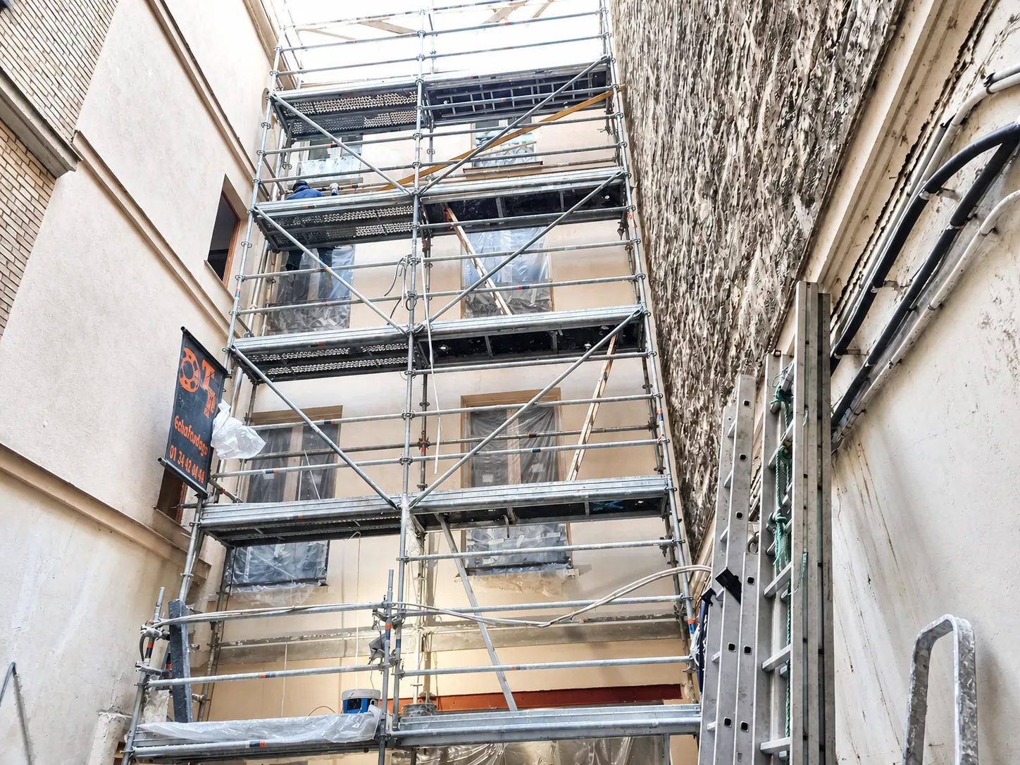 Façade de cour rue de Lévis à Paris 17e pendant le ravalement avec échafaudage et protections
