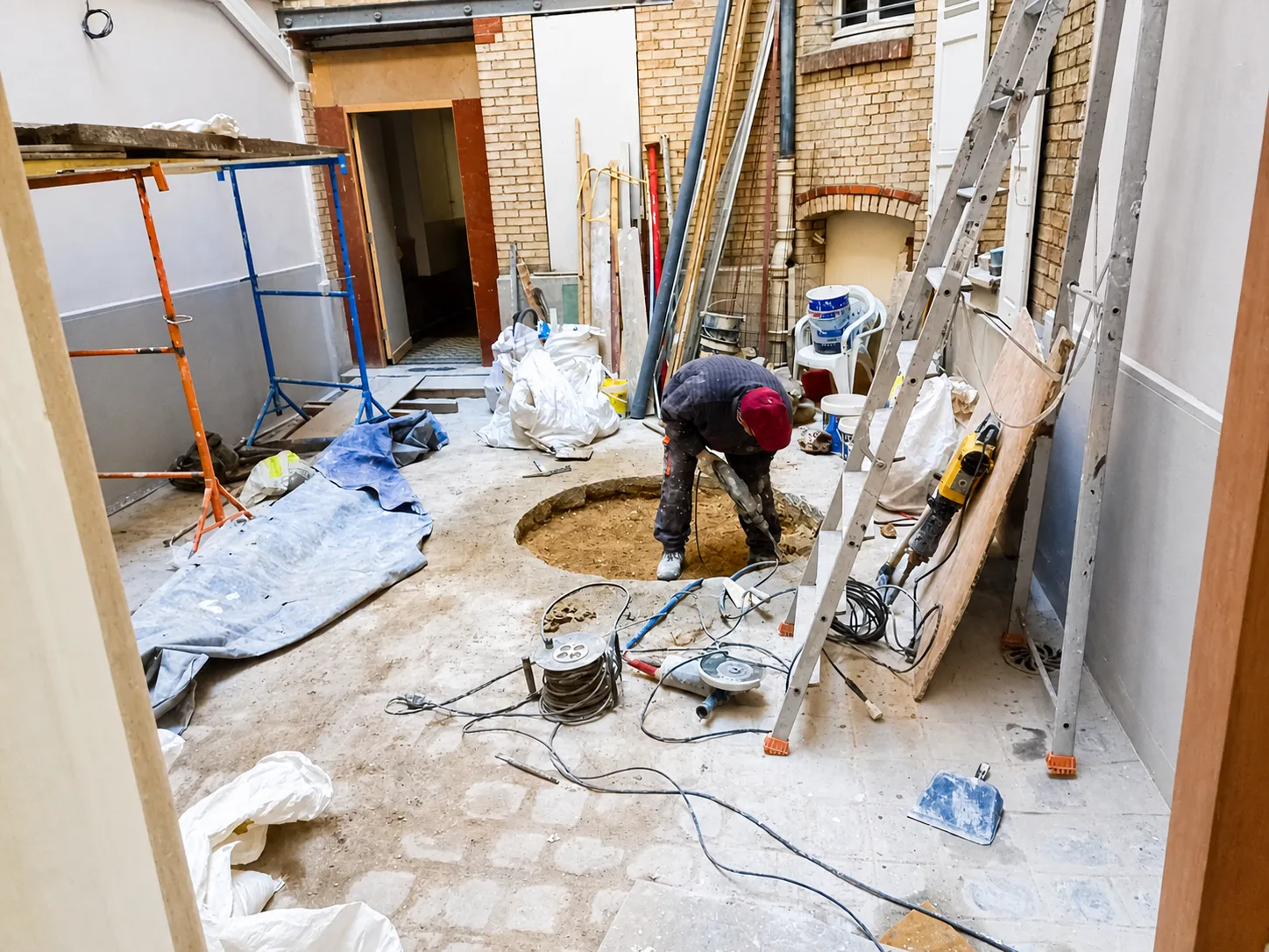 Cour intérieure rue de Lévis à Paris 17e pendant les travaux avec sol ouvert, protections et outillage