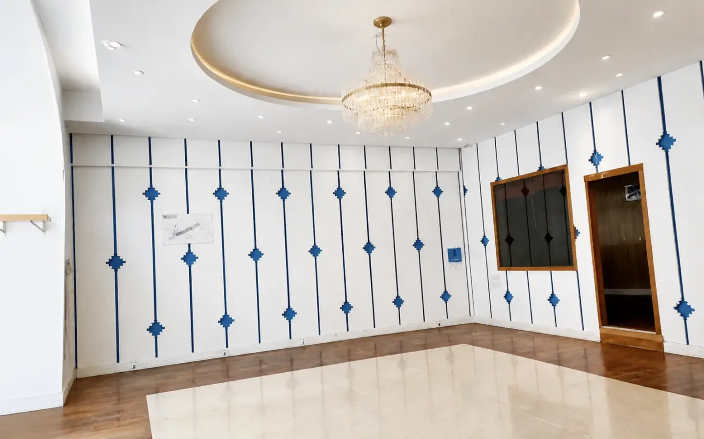 Local commercial rénové par InnovDécor SARL : lustre, faux plafond arrondi, habillage mural et sol bois avec marbre