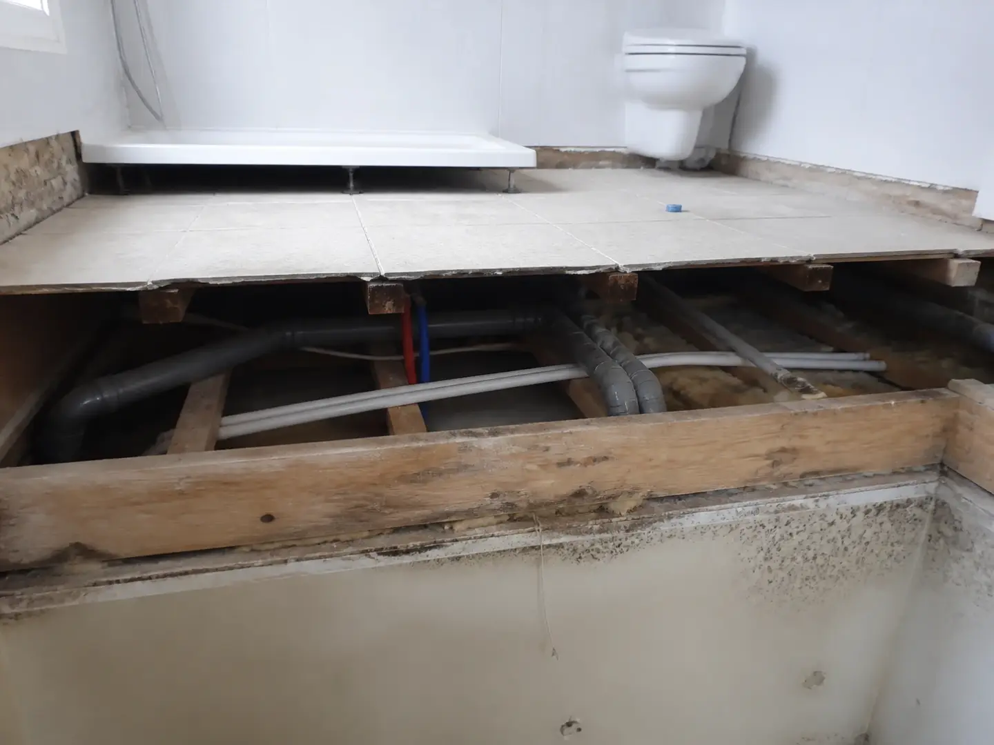 Plancher de salle de bain ouvert avec évacuations et réseaux sous carrelage